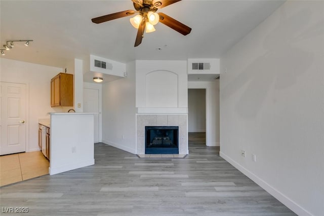 7151 S Durango Dr Unit 211, Las Vegas, NV 89113 - unfurnished living room featuring ceiling fan, baseboards, a fireplace, and light wood finished floors