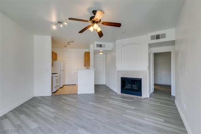 7151 S Durango Dr Unit 211, Las Vegas, NV 89113 - unfurnished living room featuring a ceiling fan, baseboards, light wood-type flooring, and a fireplace