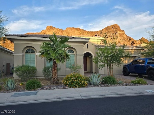 26 Costa Tropical Dr, Henderson, NV 89011 - view of front of house featuring a garage, a mountain view, driveway, and stucco siding