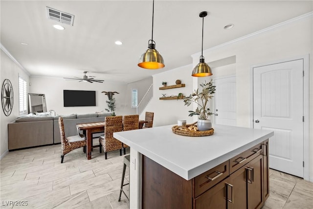 10474 Palmadora St, Las Vegas, NV 89178 - kitchen with ornamental molding, a ceiling fan, pendant lighting, light countertops, and a center island