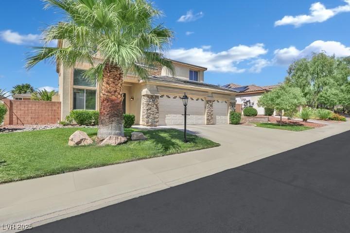 2382 Sunburst View St, Henderson, NV 89052 - view of front facade with driveway, stucco siding, stone siding, and a garage
