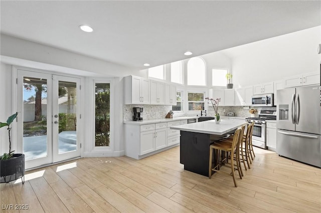 15 Pheasant Ridge Dr, Henderson, NV 89014 - kitchen featuring appliances with stainless steel finishes, a breakfast bar area, backsplash, light countertops, and a center island