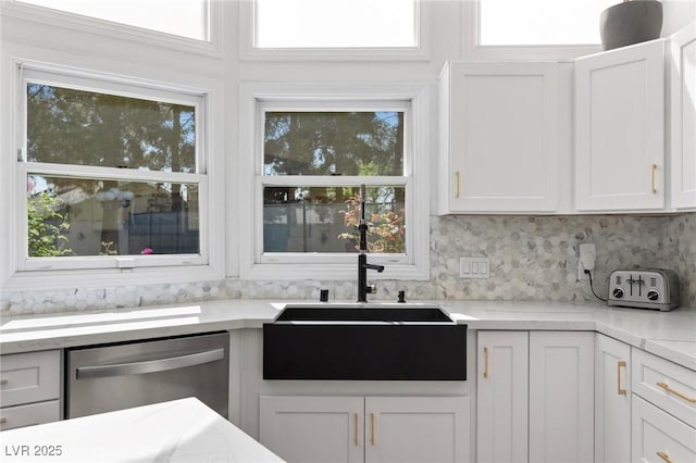 15 Pheasant Ridge Dr, Henderson, NV 89014 - kitchen with stainless steel dishwasher, a sink, white cabinets, light countertops, and decorative backsplash