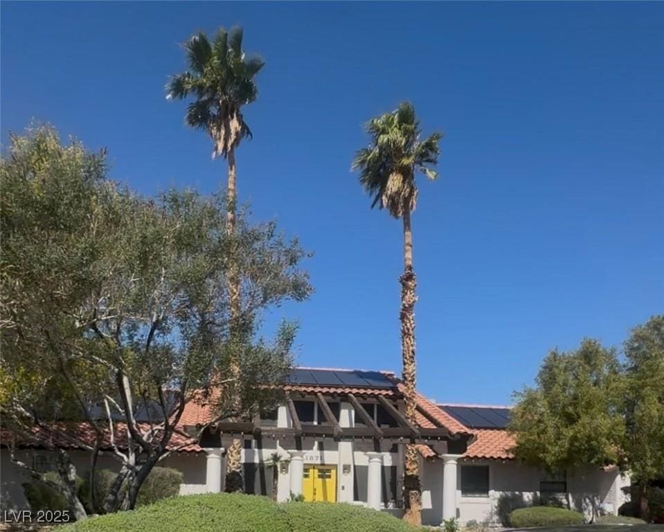 1871 Ski Slope Cir, Las Vegas, NV 89117 - view of front of home with roof mounted solar panels, stucco siding, and a tiled roof
