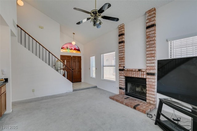 6436 Deadwood Rd, Las Vegas, NV 89108 - unfurnished living room with carpet, stairway, a ceiling fan, a brick fireplace, and high vaulted ceiling