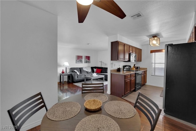 2451 N Rainbow Blvd Unit 2043, Las Vegas, NV 89108 - kitchen with appliances with stainless steel finishes, ceiling fan, light wood-style floors, light countertops, and open floor plan