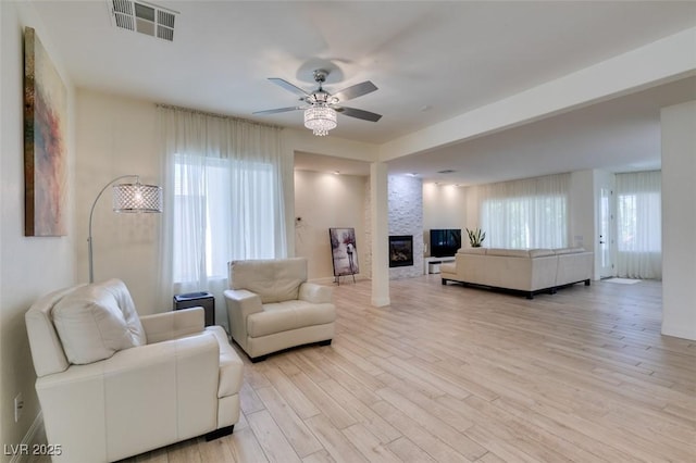 8221 Bay Dunes St, Las Vegas, NV 89131 - living area featuring a ceiling fan, a large fireplace, and light wood-style flooring