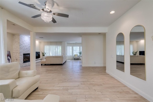 8221 Bay Dunes St, Las Vegas, NV 89131 - living area with a ceiling fan, light wood-type flooring, a stone fireplace, baseboards, and recessed lighting