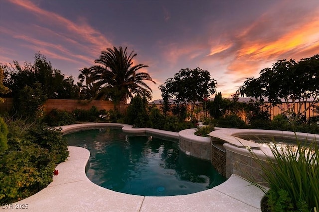 8221 Bay Dunes St, Las Vegas, NV 89131 - pool at dusk with a fenced backyard and a pool with connected hot tub