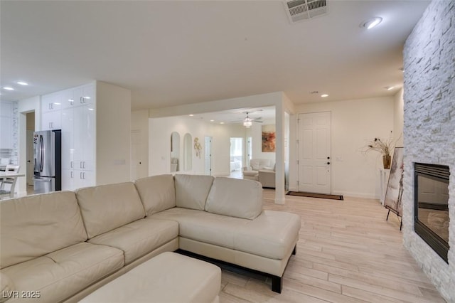8221 Bay Dunes St, Las Vegas, NV 89131 - living area featuring a fireplace, light wood-style flooring, a ceiling fan, recessed lighting, and arched walkways