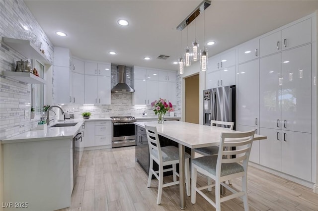 8221 Bay Dunes St, Las Vegas, NV 89131 - kitchen featuring appliances with stainless steel finishes, wall chimney range hood, a sink, modern cabinets, and recessed lighting