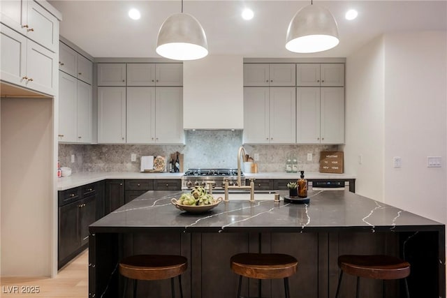 8104 Bay Harbor Dr, Las Vegas, NV 89128 - kitchen with backsplash, light wood finished floors, gray cabinetry, a breakfast bar area, and recessed lighting