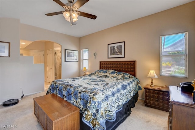 805 Palmero Way, Boulder City, NV 89005 - bedroom with light colored carpet, arched walkways, multiple windows, and a ceiling fan
