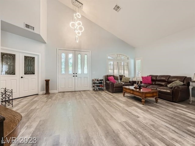 9718 Camino Capistrano Ln, Las Vegas, NV 89147 - living room featuring high vaulted ceiling, light wood-style floors, healthy amount of natural light, french doors, and baseboards