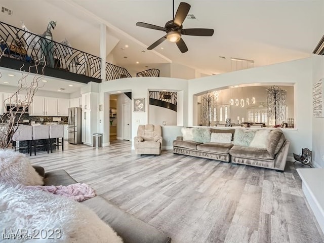 9718 Camino Capistrano Ln, Las Vegas, NV 89147 - living area featuring arched walkways, light wood-style floors, ceiling fan, and high vaulted ceiling