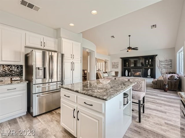 9718 Camino Capistrano Ln, Las Vegas, NV 89147 - kitchen featuring stainless steel fridge with ice dispenser, ceiling fan, white cabinetry, light wood-type flooring, and stone countertops