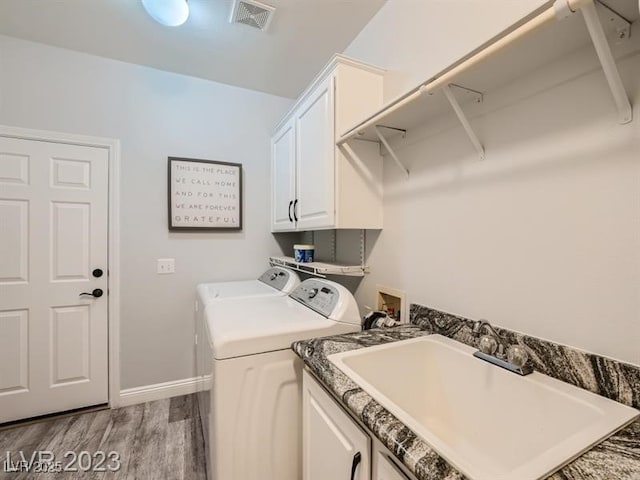 9718 Camino Capistrano Ln, Las Vegas, NV 89147 - washroom featuring cabinet space, washer and clothes dryer, wood finished floors, and baseboards