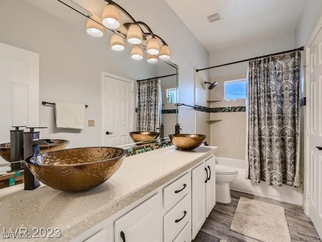 9718 Camino Capistrano Ln, Las Vegas, NV 89147 - full bathroom with double vanity, shower / tub combo, toilet, and wood finished floors
