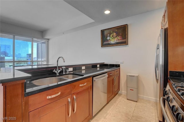4525 Dean Martin Dr Unit 901, Las Vegas, NV 89103 - kitchen with stainless steel appliances, a sink, brown cabinets, dark stone counters, and light tile patterned floors