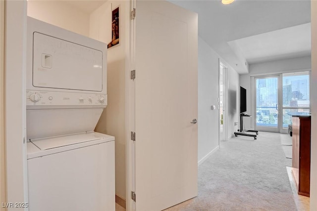 4525 Dean Martin Dr Unit 901, Las Vegas, NV 89103 - laundry area featuring stacked washing machine and dryer, light carpet, and baseboards