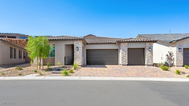 362 Tigullio Ave, Henderson, NV 89011 - view of front of property featuring an attached garage, decorative driveway, stucco siding, and stone siding