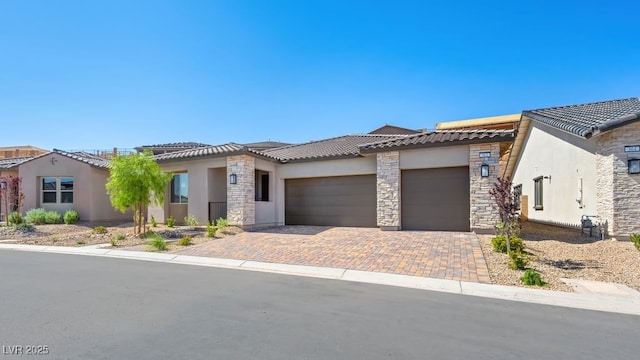 362 Tigullio Ave, Henderson, NV 89011 - view of front facade with a garage, a tile roof, stone siding, stucco siding, and decorative driveway