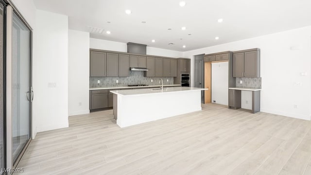 362 Tigullio Ave, Henderson, NV 89011 - kitchen with a sink, gray cabinets, tasteful backsplash, double oven, and an island with sink