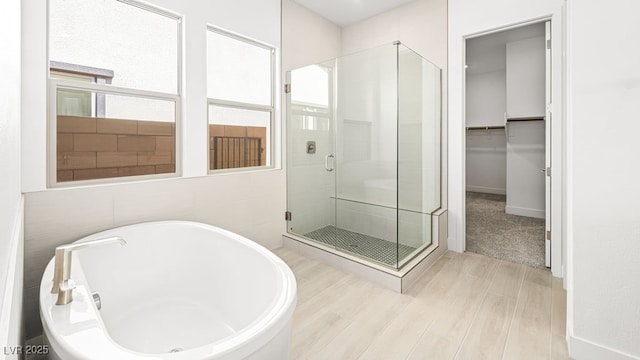 362 Tigullio Ave, Henderson, NV 89011 - full bathroom with a stall shower, a soaking tub, wood finished floors, baseboards, and a spacious closet