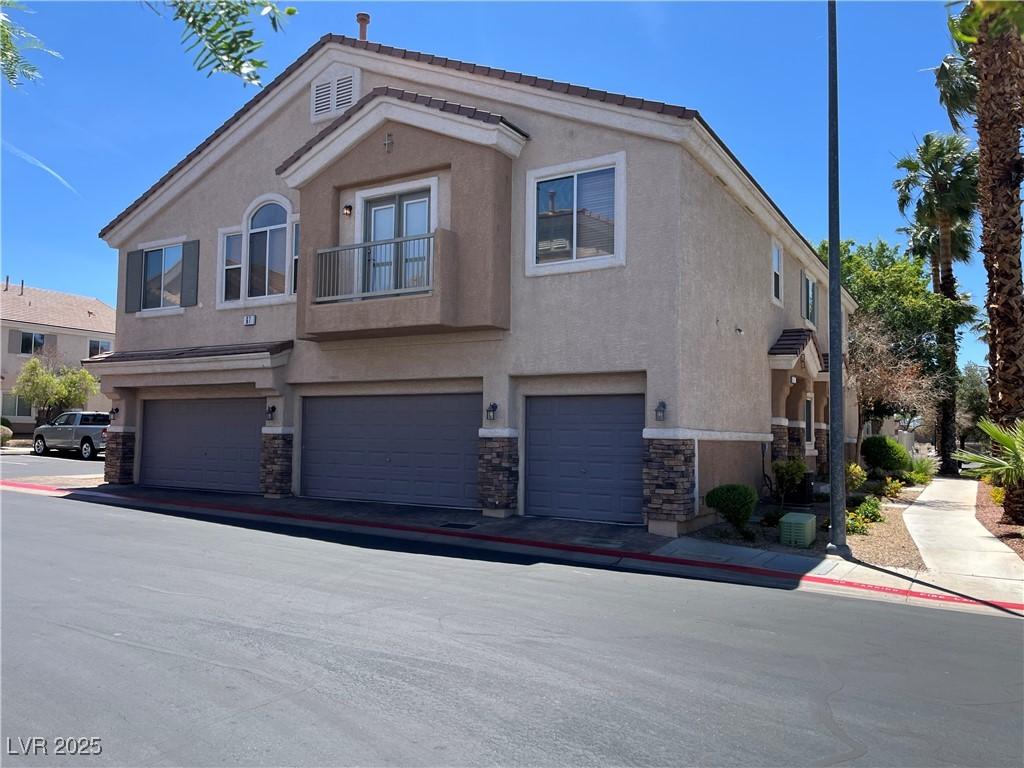 67 Dow Jones St Unit 2, Henderson, NV 89074 - view of front facade featuring stone siding, stucco siding, and a garage