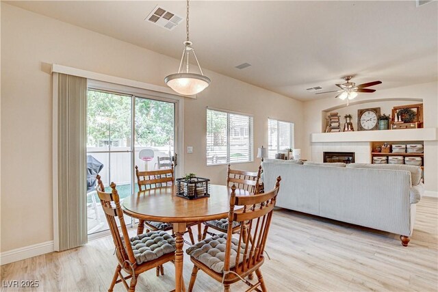 67 Dow Jones St Unit 2, Henderson, NV 89074 - dining space featuring plenty of natural light, light wood-style floors, ceiling fan, and a tiled fireplace