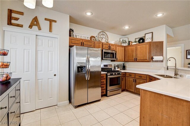 67 Dow Jones St Unit 2, Henderson, NV 89074 - kitchen featuring appliances with stainless steel finishes, a sink, brown cabinetry, light tile patterned flooring, and recessed lighting