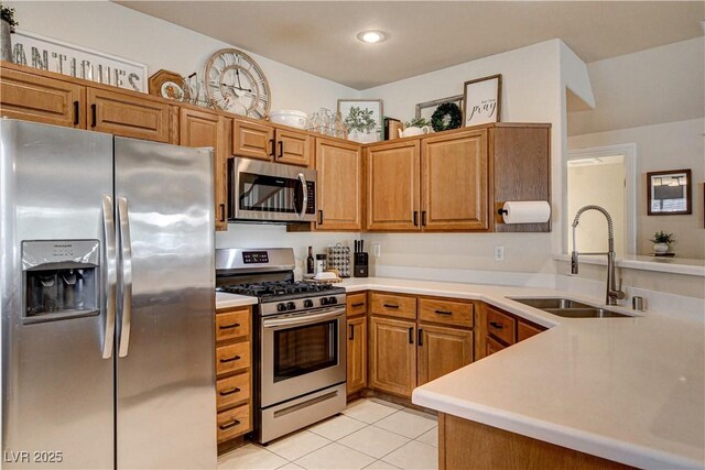 67 Dow Jones St Unit 2, Henderson, NV 89074 - kitchen featuring appliances with stainless steel finishes, a sink, light tile patterned flooring, light countertops, and a peninsula
