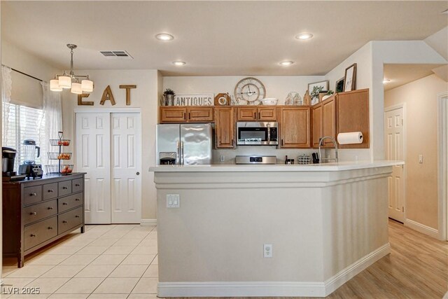 67 Dow Jones St Unit 2, Henderson, NV 89074 - kitchen with appliances with stainless steel finishes, a chandelier, light countertops, recessed lighting, and brown cabinetry