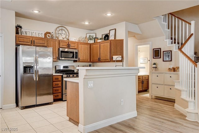 67 Dow Jones St Unit 2, Henderson, NV 89074 - kitchen with stainless steel appliances, brown cabinets, light countertops, light wood-style floors, and recessed lighting