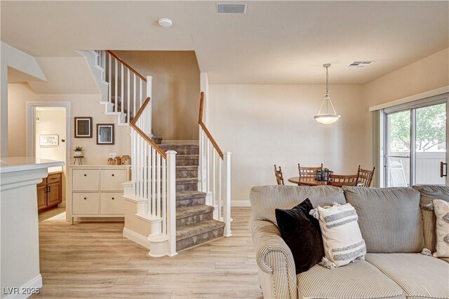 67 Dow Jones St Unit 2, Henderson, NV 89074 - living room featuring stairs, light wood-style flooring, and baseboards