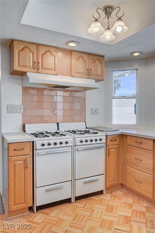 3143 El Chico Ct, Las Vegas, NV 89120 - kitchen with white range with gas cooktop, under cabinet range hood, a chandelier, and light countertops