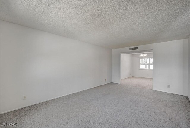 3143 El Chico Ct, Las Vegas, NV 89120 - empty room featuring carpet, a textured ceiling, and a chandelier