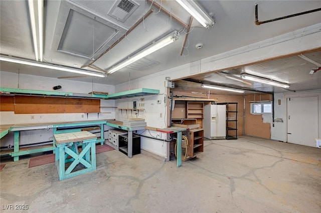 3143 El Chico Ct, Las Vegas, NV 89120 - garage with a workshop area and white fridge with ice dispenser