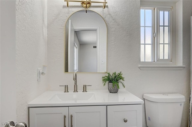 4496 Skyview Dr, Las Vegas, NV 89104 - bathroom featuring vanity, a textured wall, and toilet
