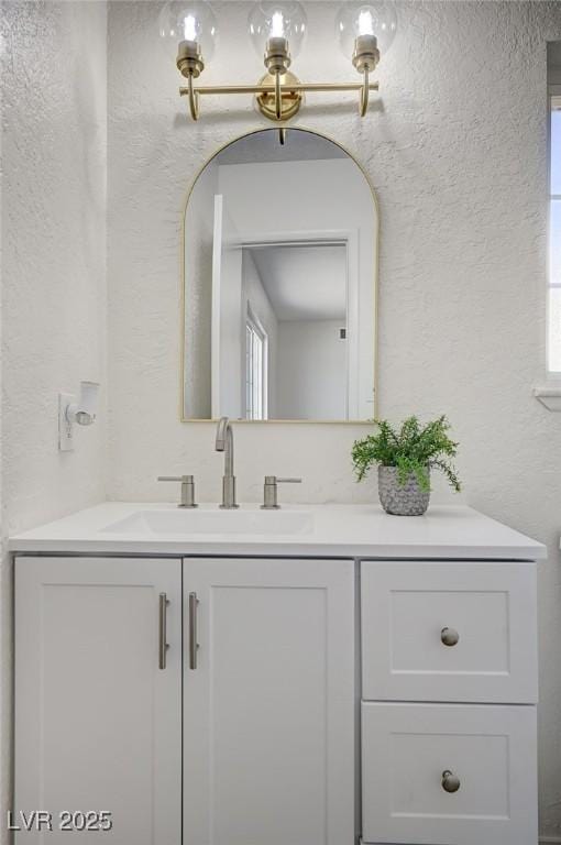 4496 Skyview Dr, Las Vegas, NV 89104 - bathroom featuring a textured wall, vanity, and healthy amount of natural light