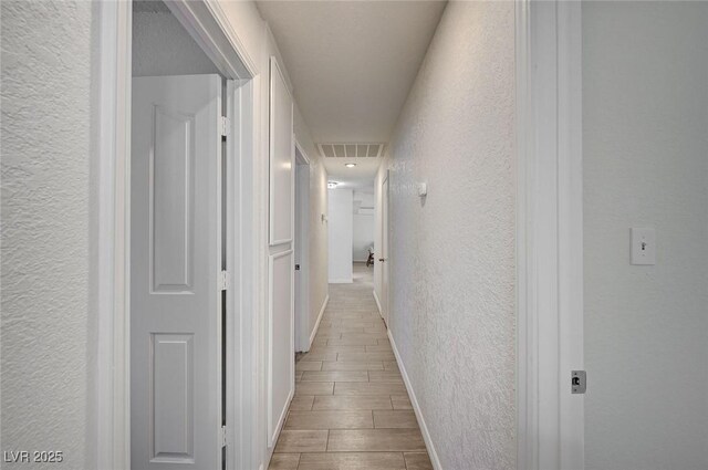 4496 Skyview Dr, Las Vegas, NV 89104 - hallway with a textured wall, baseboards, and wood tiled floors