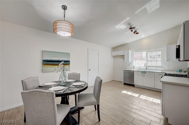 4496 Skyview Dr, Las Vegas, NV 89104 - dining space featuring vaulted ceiling, light wood-type flooring, and baseboards