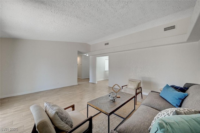 4496 Skyview Dr, Las Vegas, NV 89104 - living room with a textured ceiling, light wood-style flooring, and baseboards