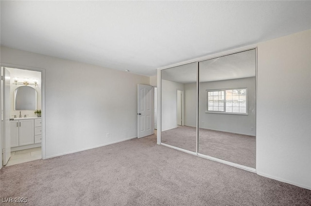 4496 Skyview Dr, Las Vegas, NV 89104 - unfurnished bedroom featuring carpet flooring, a closet, connected bathroom, and a sink