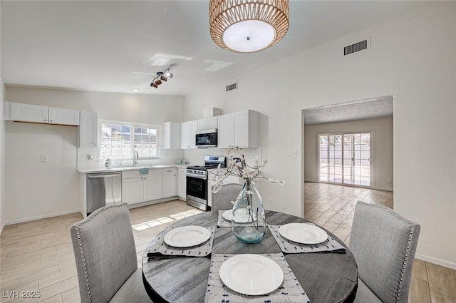 4496 Skyview Dr, Las Vegas, NV 89104 - dining room featuring light wood-style floors, high vaulted ceiling, and baseboards