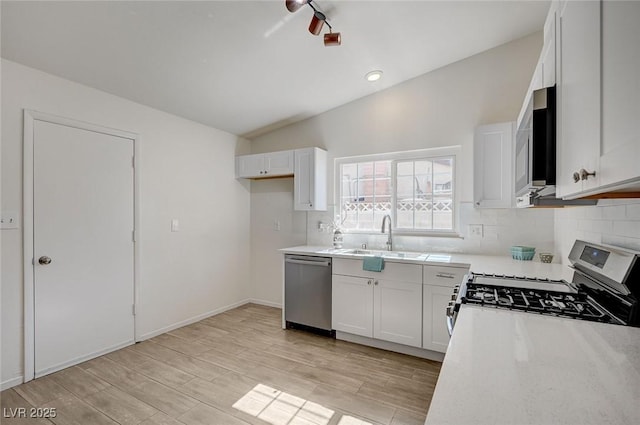 4496 Skyview Dr, Las Vegas, NV 89104 - kitchen with appliances with stainless steel finishes, a sink, tasteful backsplash, light countertops, and vaulted ceiling