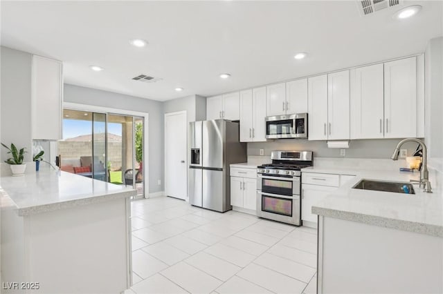 3966 Crystal Trip Ct, Las Vegas, NV 89129 - kitchen with stainless steel appliances, a sink, recessed lighting, light tile patterned floors, and white cabinetry