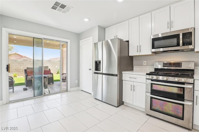 3966 Crystal Trip Ct, Las Vegas, NV 89129 - kitchen with stainless steel appliances, light countertops, white cabinets, baseboards, and recessed lighting