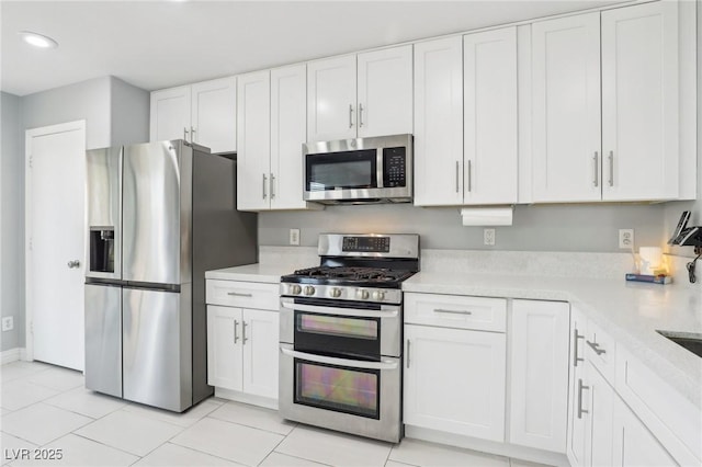 3966 Crystal Trip Ct, Las Vegas, NV 89129 - kitchen with appliances with stainless steel finishes, light countertops, white cabinetry, light tile patterned floors, and recessed lighting