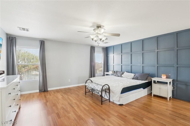 3966 Crystal Trip Ct, Las Vegas, NV 89129 - bedroom with a decorative wall, multiple windows, light wood-type flooring, baseboards, and ceiling fan